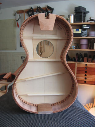 This photo shows the inside of the same guitar. You can see how the two braces that cross the lower bout are not parallel. Instead, the braces get further away from each other toward the bass side of the soundboard.
